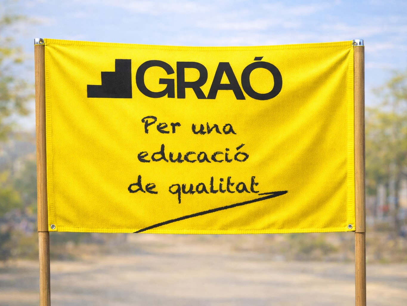 Pancarta groga amb el text "GRAÓ: Per una educació de qualitat"
